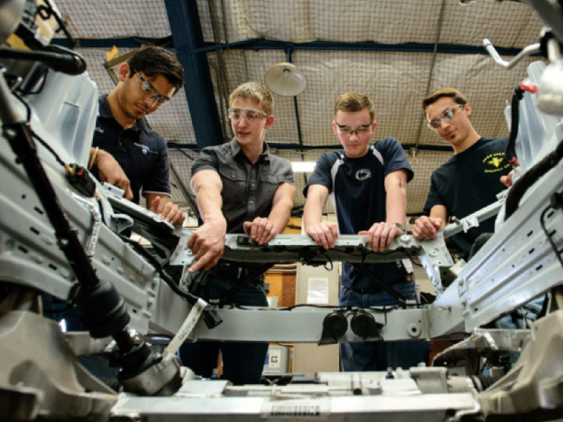 Engineering students study the frame of an automobile